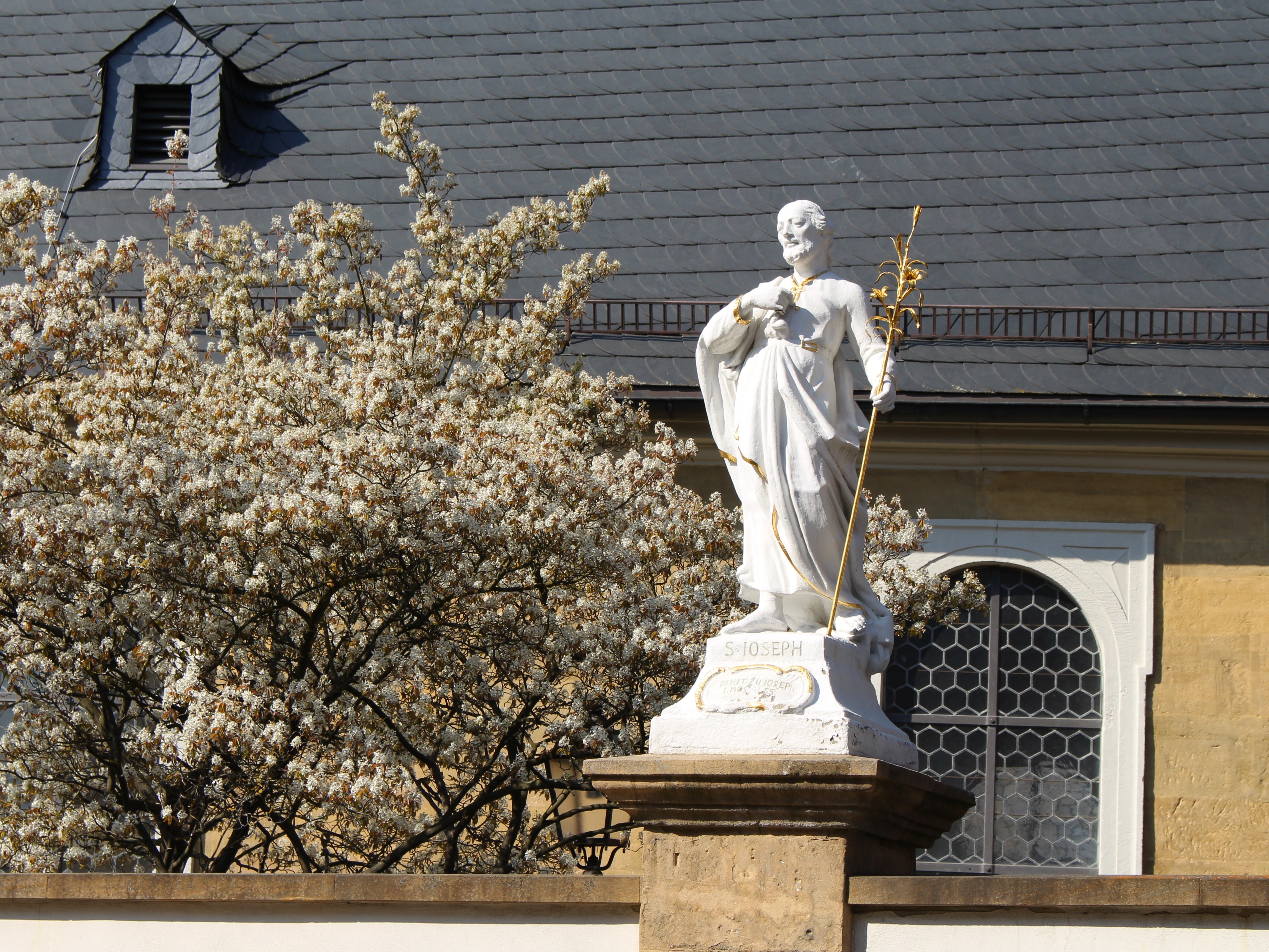 Die kath. Pfarrkirche Maria Himmelfahrt mit ihrer Mauer, gekrönt von Engels- und Heiligenstatuen aus der Hand des Bildhauers Ferdinand Dietz